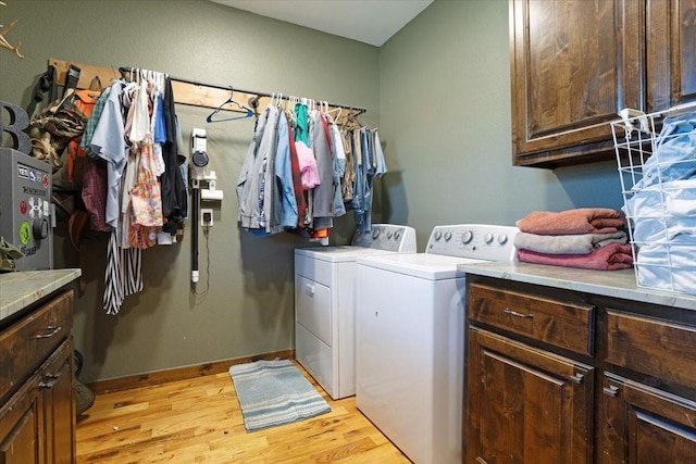 clothes washing area featuring cabinets, separate washer and dryer, and light hardwood / wood-style floors