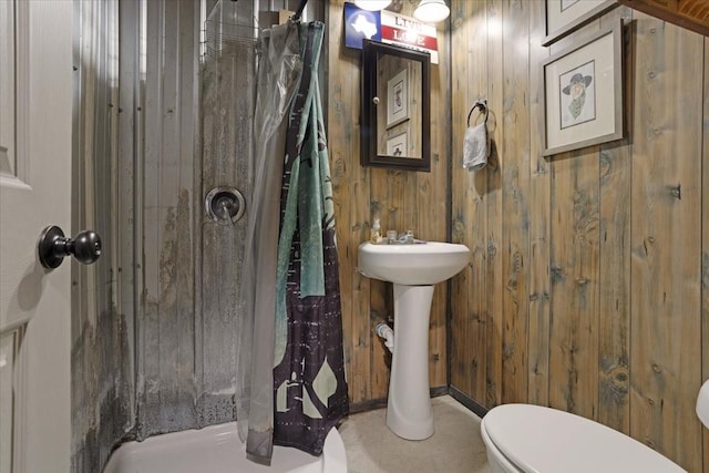 bathroom with toilet, wood walls, and a shower with shower curtain