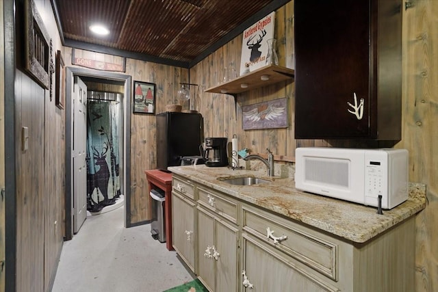 kitchen with light stone counters, sink, wooden walls, and wooden ceiling