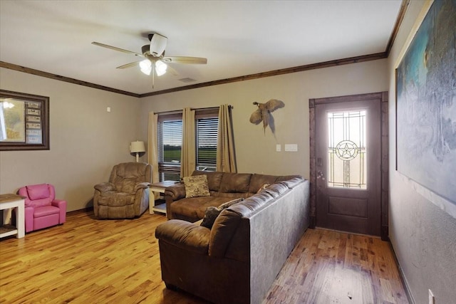 living room featuring crown molding, ceiling fan, and light wood-type flooring