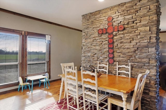 dining room with wood-type flooring and ornamental molding