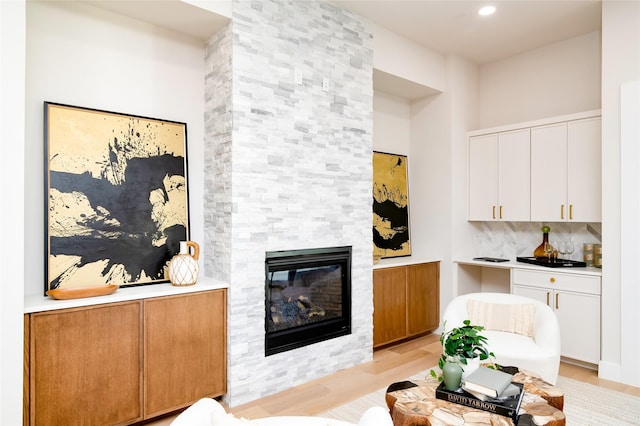 living room featuring a large fireplace and light wood-type flooring