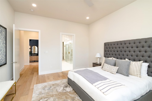 bedroom with ensuite bath and light hardwood / wood-style flooring