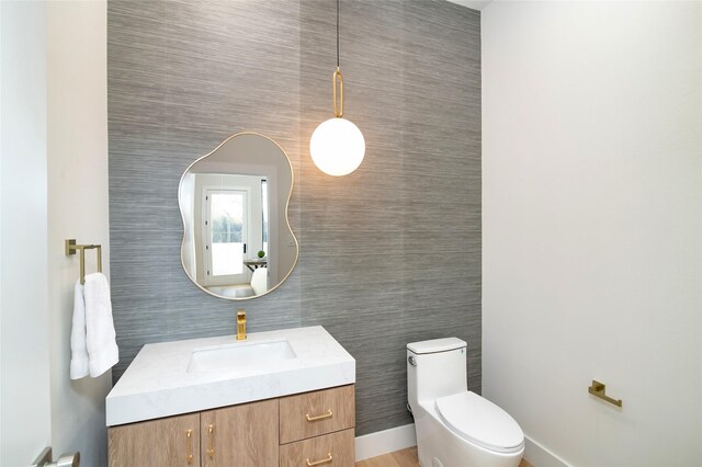 bathroom featuring vanity, toilet, and tile walls