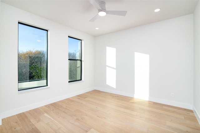 empty room with ceiling fan, light hardwood / wood-style floors, and a wealth of natural light