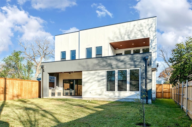 rear view of house featuring a lawn, ceiling fan, and a patio area