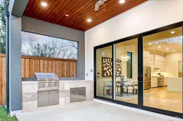 view of patio featuring exterior kitchen, area for grilling, sink, and ceiling fan