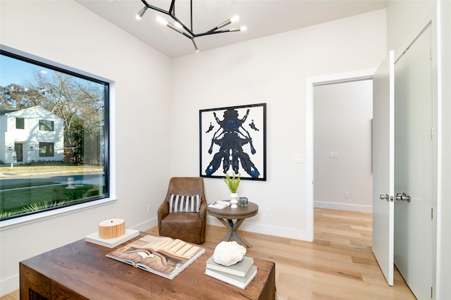 sitting room with light wood-type flooring and a notable chandelier