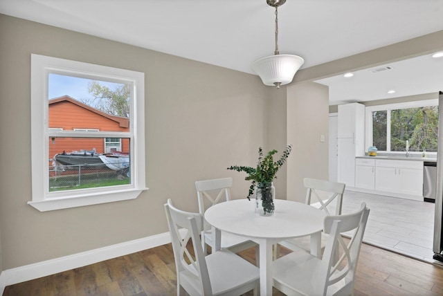 dining area with plenty of natural light, dark hardwood / wood-style floors, and sink