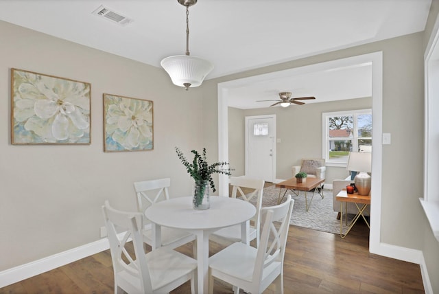 dining area with ceiling fan and dark wood-type flooring