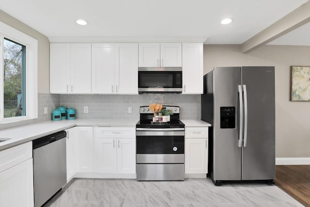 kitchen featuring white cabinets, decorative backsplash, and stainless steel appliances