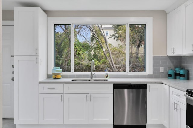 kitchen with backsplash, stainless steel dishwasher, sink, and white cabinets