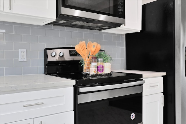 kitchen featuring tasteful backsplash, white cabinets, and stainless steel appliances