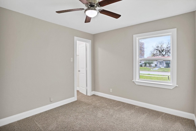 carpeted spare room featuring ceiling fan