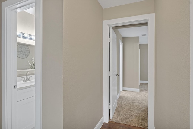 hallway with sink and dark wood-type flooring