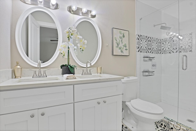 bathroom with vanity, toilet, and a shower with door