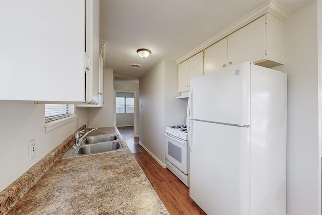 kitchen with sink, white appliances, and hardwood / wood-style flooring