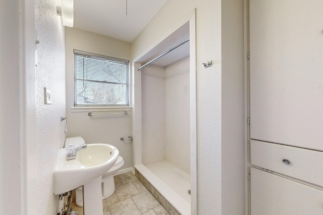 bathroom featuring toilet, tile patterned floors, and walk in shower