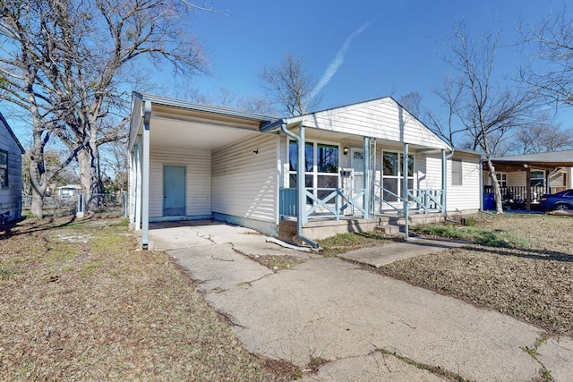 ranch-style home with a porch and a carport