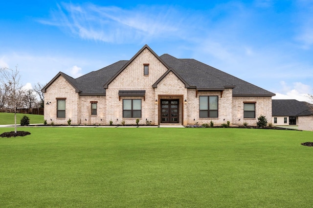 french country style house featuring french doors and a front lawn