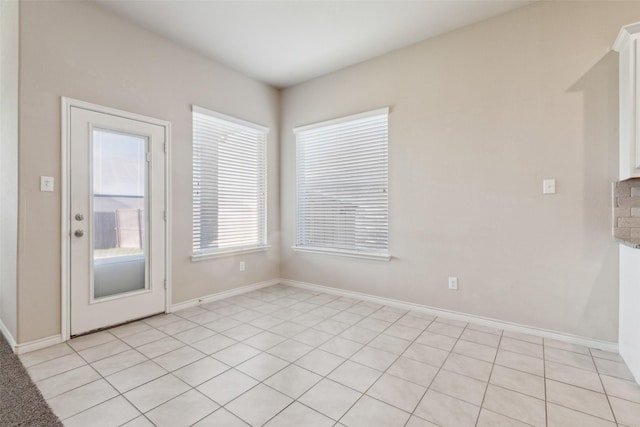 unfurnished dining area featuring light tile patterned flooring