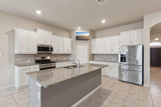 kitchen with light tile patterned flooring, stainless steel appliances, white cabinetry, and sink