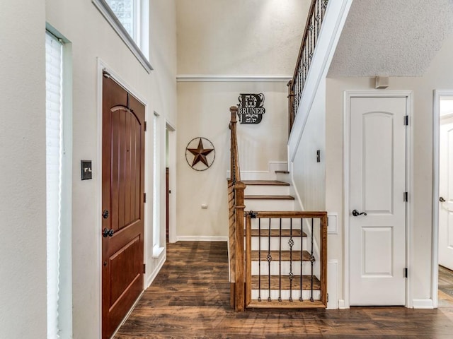 entrance foyer with dark hardwood / wood-style flooring and a textured ceiling