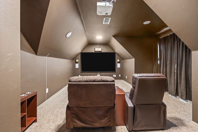 carpeted cinema room with a textured ceiling and vaulted ceiling