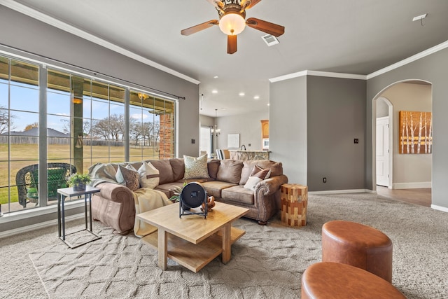 living room featuring ceiling fan, crown molding, and light carpet