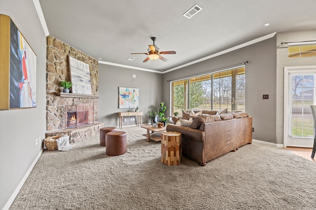 living room with carpet, a stone fireplace, crown molding, and ceiling fan