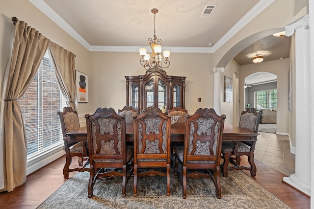 dining room featuring dark hardwood / wood-style flooring, ornamental molding, and a chandelier