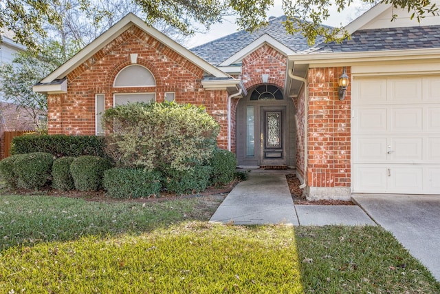 entrance to property featuring a garage and a lawn