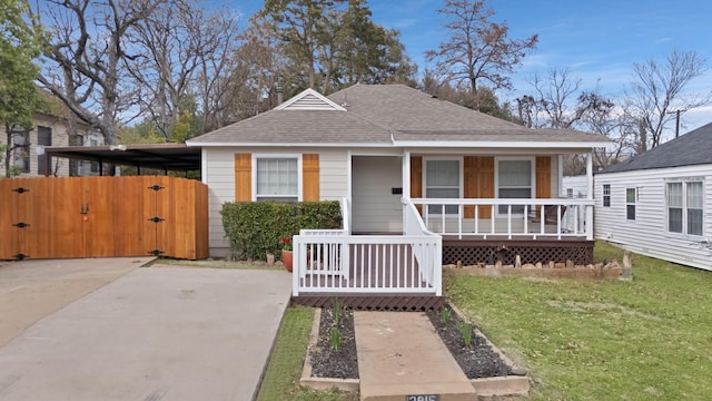 bungalow-style home with a front lawn, a gate, covered porch, a shingled roof, and a carport