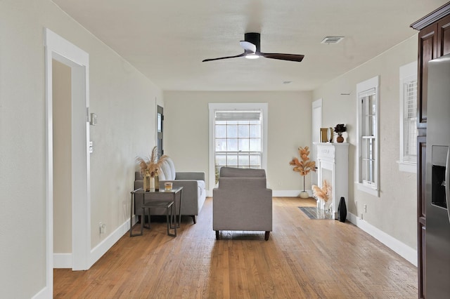 living area featuring ceiling fan and light wood-type flooring