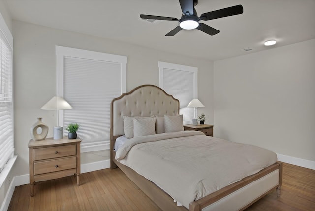 bedroom with baseboards, wood-type flooring, and ceiling fan