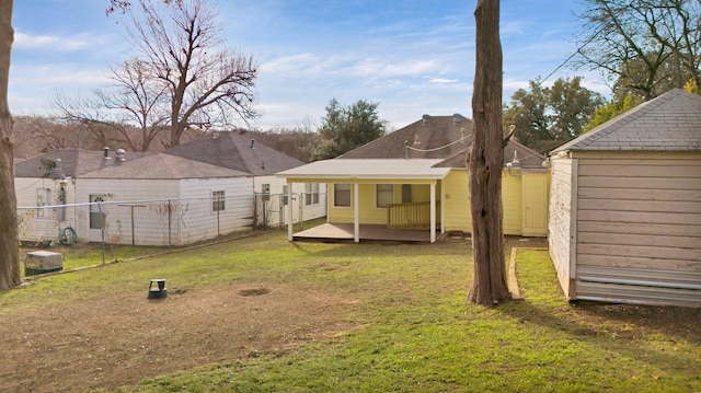 rear view of house featuring a storage unit and a lawn