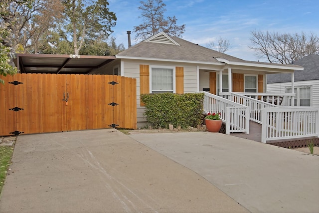 view of front of home featuring a porch, a gate, fence, and roof with shingles