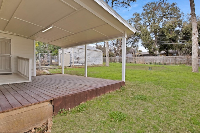 deck with an outbuilding, a fenced backyard, and a lawn