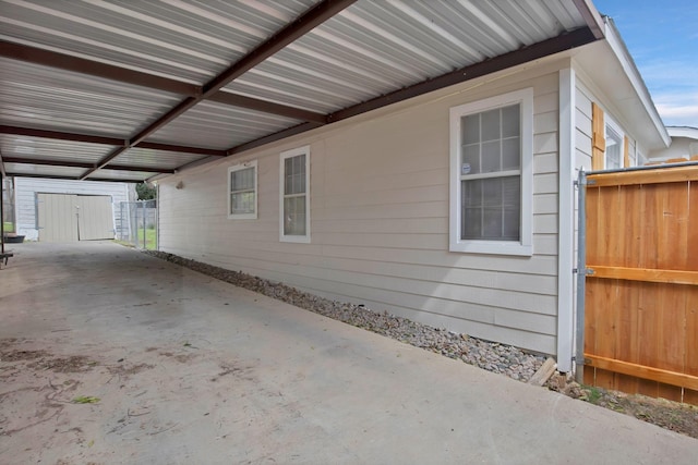 view of side of property featuring a carport and fence