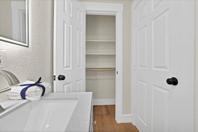 clothes washing area featuring hardwood / wood-style flooring and sink