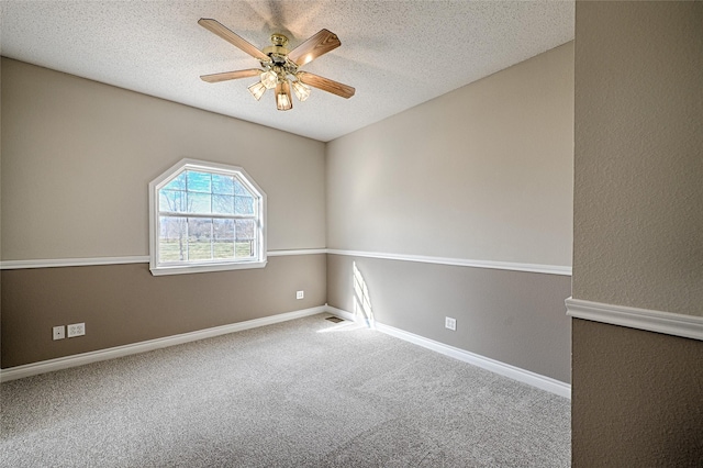 empty room with carpet flooring, ceiling fan, and a textured ceiling