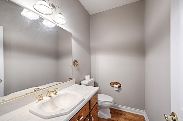 bathroom with vanity, wood-type flooring, and toilet