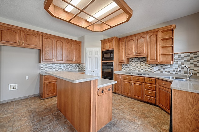 kitchen featuring decorative backsplash, a center island, black appliances, and sink