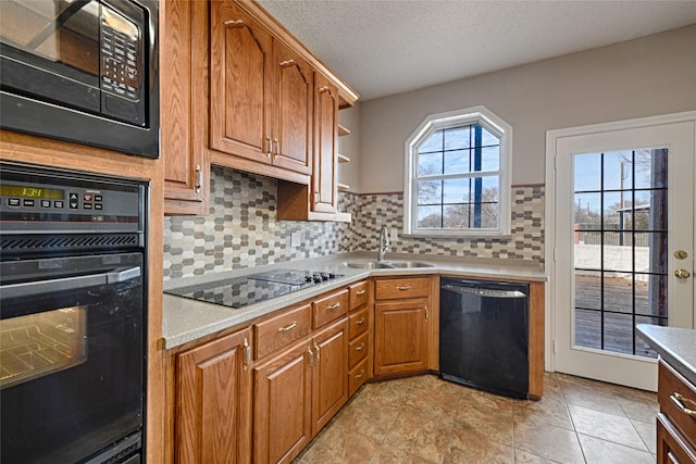 kitchen with black appliances, sink, decorative backsplash, a textured ceiling, and light tile patterned flooring