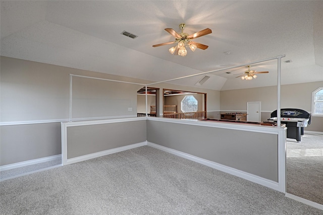 carpeted empty room featuring ceiling fan and vaulted ceiling