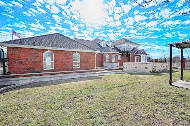 back of house with a balcony and a yard