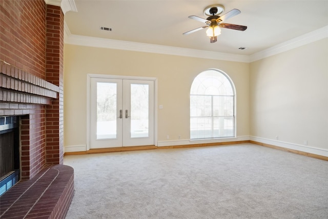 unfurnished living room with carpet, french doors, a brick fireplace, and crown molding