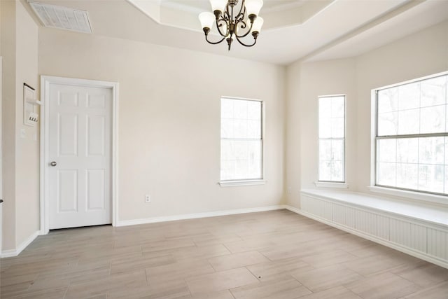 unfurnished room featuring baseboards, wood tiled floor, visible vents, and an inviting chandelier