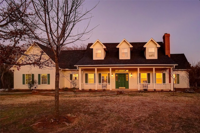 cape cod home with a chimney and a porch