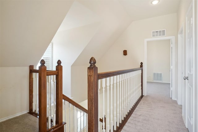 hall featuring visible vents, light carpet, and an upstairs landing